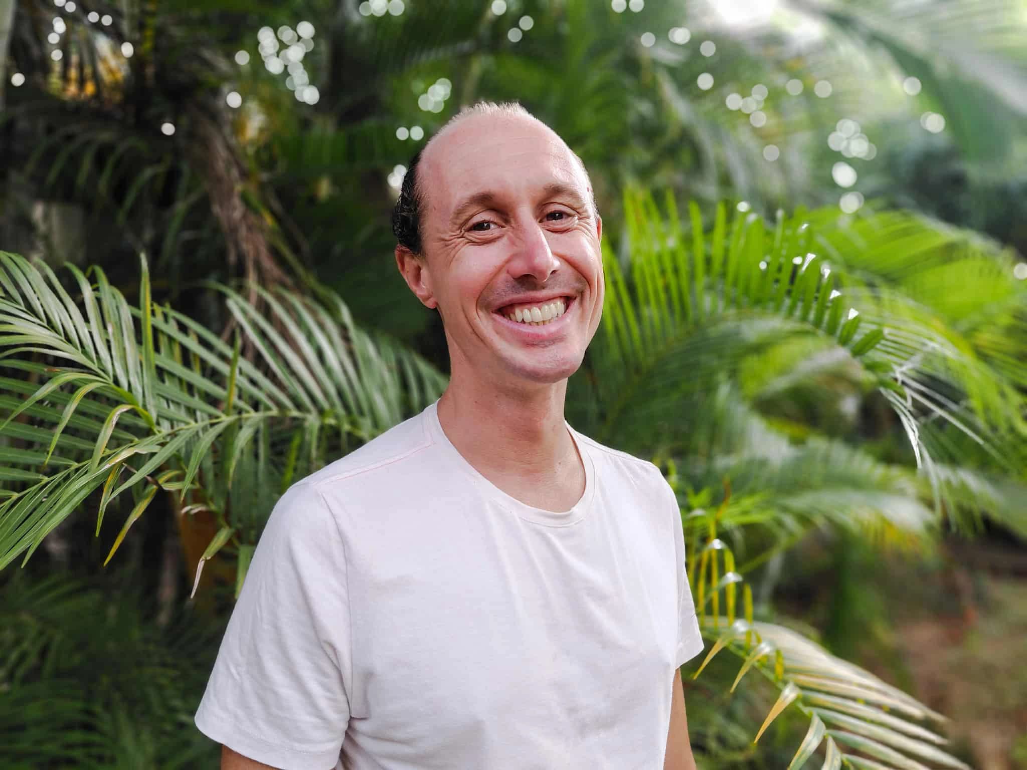 Professional picture of Yannick Le Guennec aka The Wise Duck Dev, AI Integration & Automation Specialist and Full-Stack JavaScript developer, in a tropical plant background